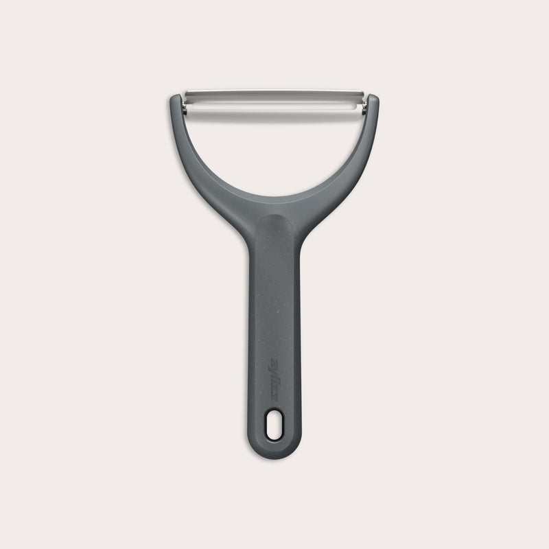 The Zyliss Wide Peeler features a Y-shaped design, ergonomic handle, and horizontal stainless steel blade, shown against a simple light background.